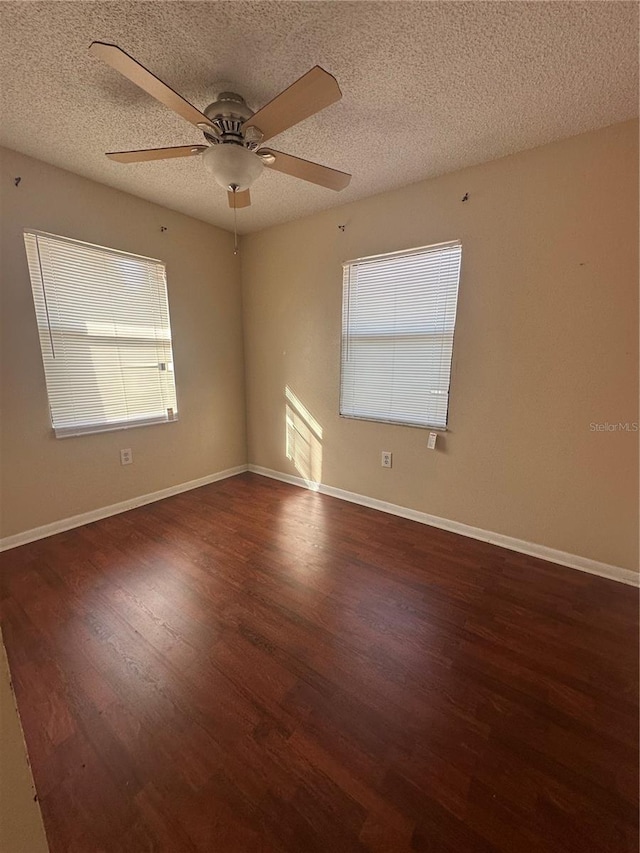 empty room featuring a textured ceiling, ceiling fan, and dark hardwood / wood-style floors