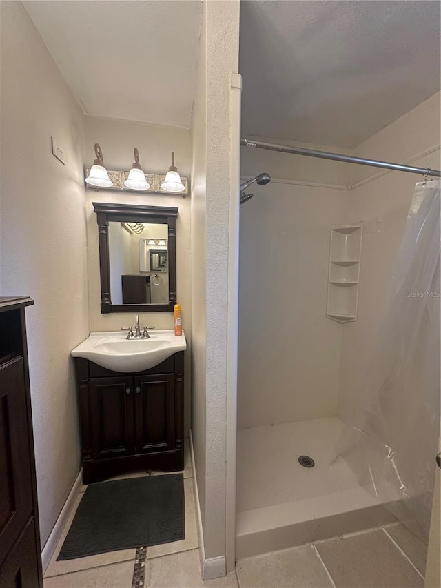 bathroom featuring vanity, tile patterned flooring, and walk in shower