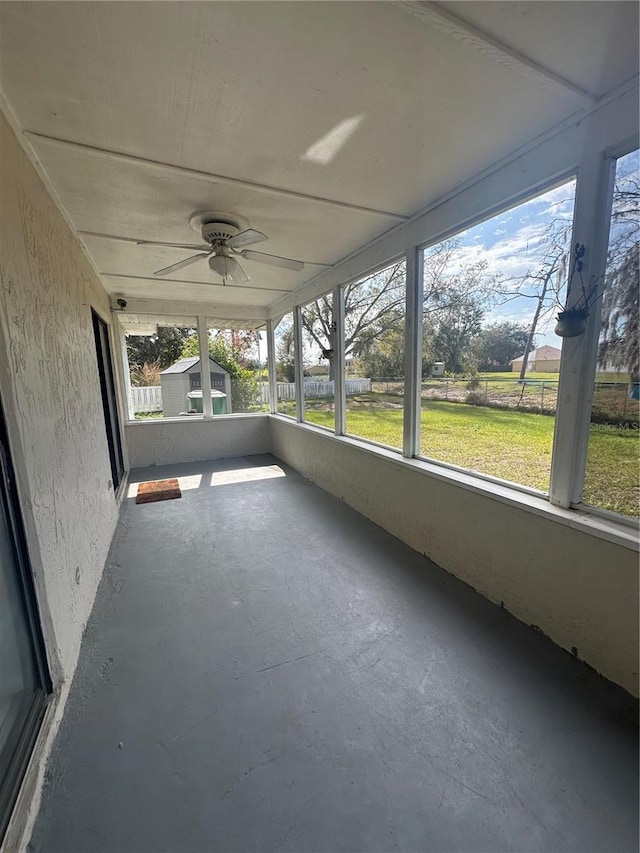 unfurnished sunroom with ceiling fan