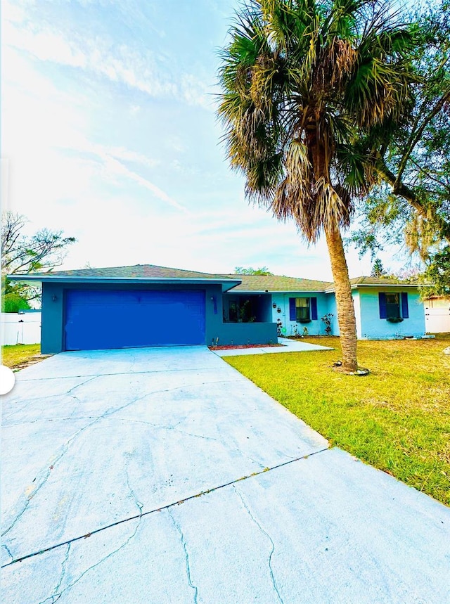 ranch-style house featuring a front yard and a garage