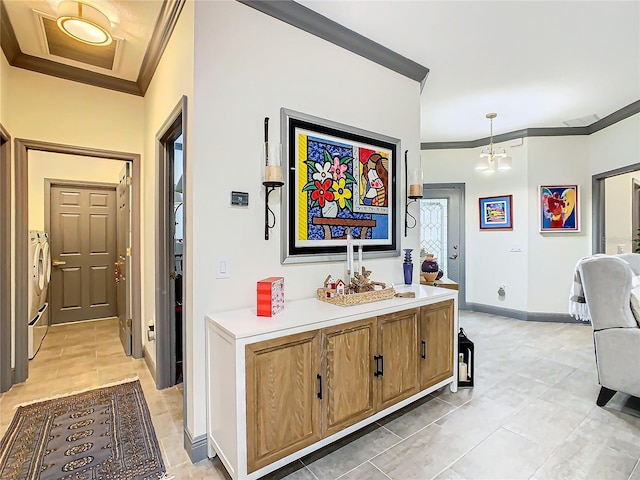 interior space featuring pendant lighting, light tile patterned floors, a notable chandelier, ornamental molding, and washing machine and clothes dryer