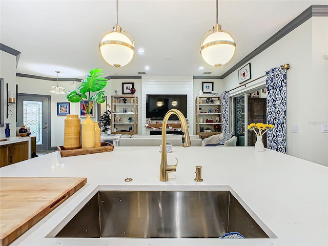 kitchen with crown molding, decorative light fixtures, and sink