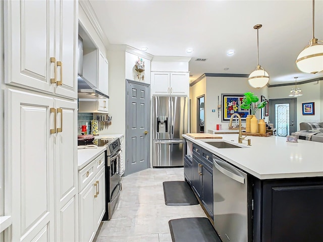 kitchen featuring pendant lighting, sink, appliances with stainless steel finishes, white cabinets, and a center island with sink