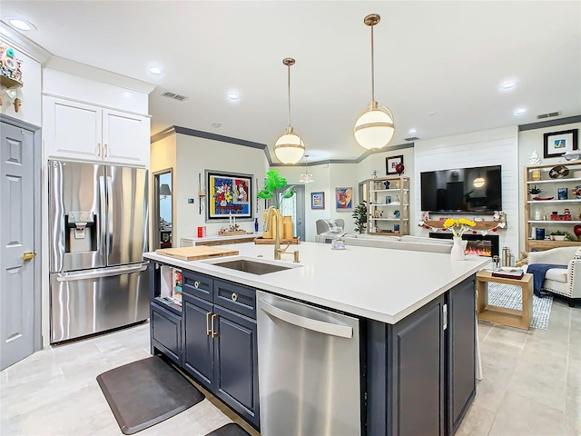 kitchen featuring sink, decorative light fixtures, a center island with sink, appliances with stainless steel finishes, and white cabinets