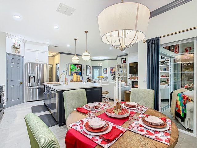 dining space with sink and crown molding