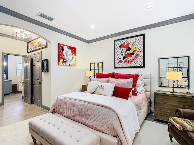 bedroom featuring ensuite bathroom and ornamental molding