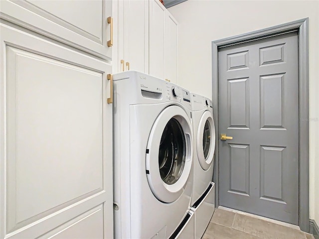 laundry room with cabinets, independent washer and dryer, and light tile patterned flooring