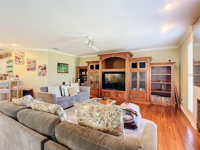 living room featuring ceiling fan, light hardwood / wood-style flooring, and crown molding