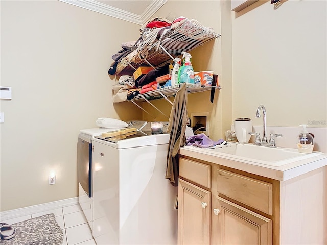 washroom with light tile patterned floors, sink, washer and clothes dryer, and crown molding