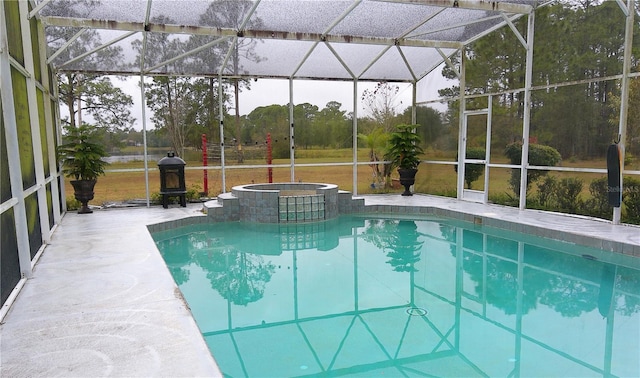 view of pool featuring glass enclosure, an in ground hot tub, and a patio area