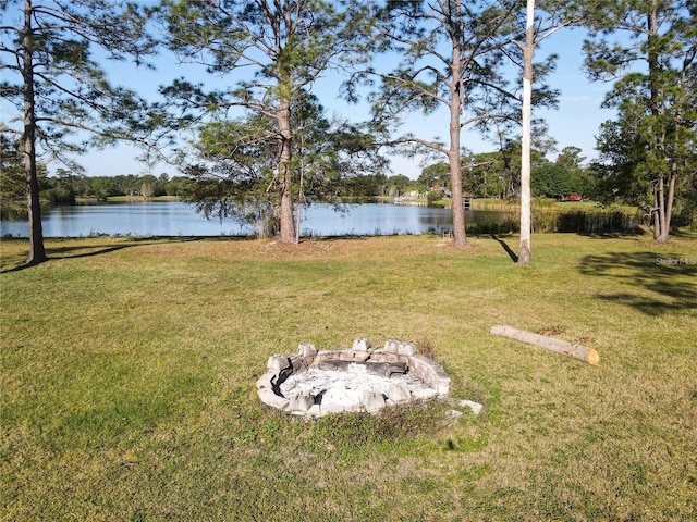 view of yard with an outdoor fire pit and a water view