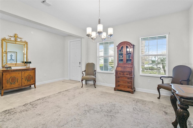 sitting room featuring a healthy amount of sunlight, light tile patterned floors, and a chandelier