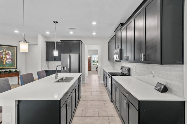 kitchen featuring hanging light fixtures, decorative backsplash, appliances with stainless steel finishes, and sink