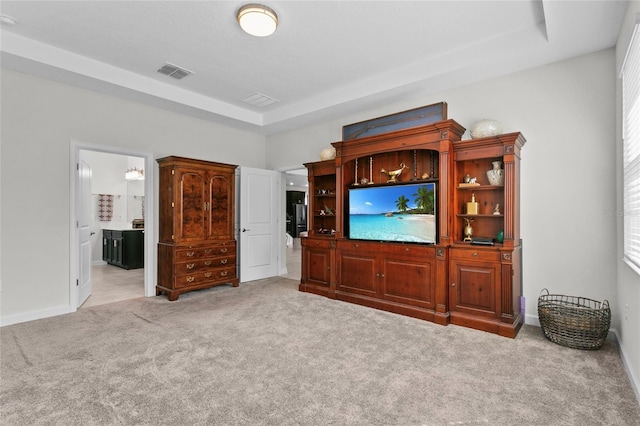 carpeted living room with a raised ceiling