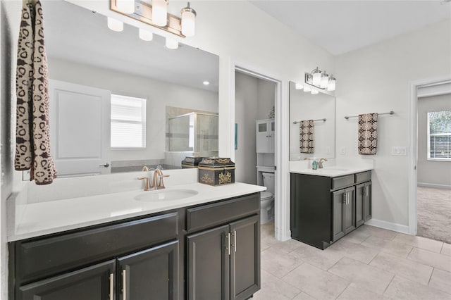 bathroom featuring toilet, vanity, tile patterned flooring, and a shower with door