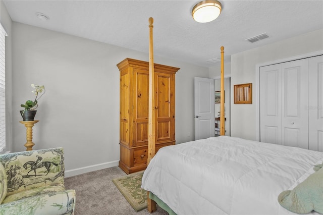 bedroom with a textured ceiling, a closet, and light colored carpet