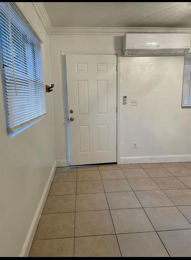 entrance foyer featuring light tile patterned floors, crown molding, and a wall mounted air conditioner