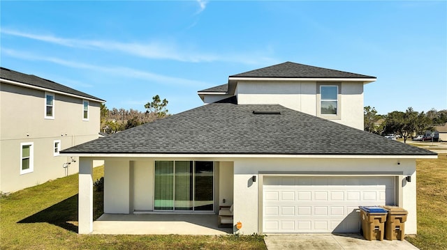 rear view of house featuring a garage, a patio area, and a lawn