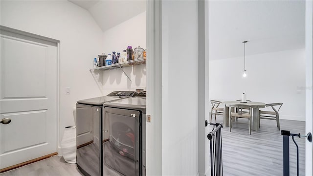 laundry area with washer and clothes dryer and light wood-type flooring