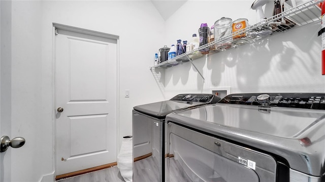 clothes washing area featuring independent washer and dryer and light hardwood / wood-style floors