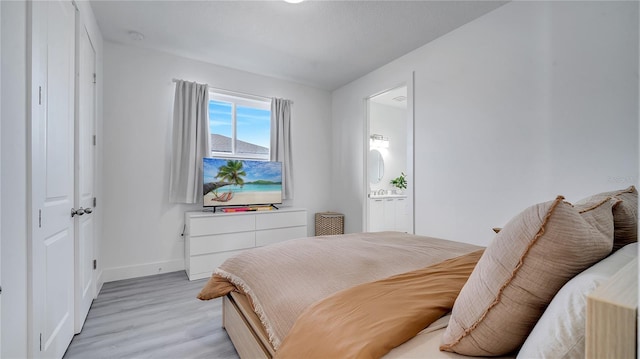 bedroom featuring light hardwood / wood-style floors and ensuite bathroom