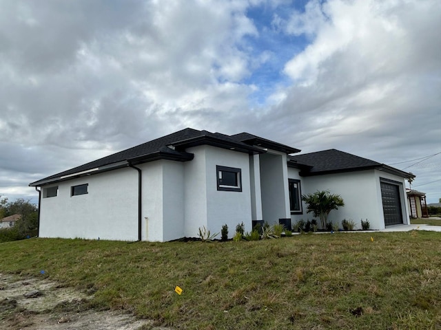 view of home's exterior with a garage and a lawn