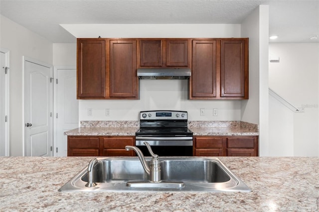 kitchen with stainless steel electric range oven, sink, and a textured ceiling