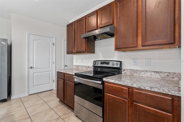 kitchen featuring light tile patterned floors, electric range, and a textured ceiling