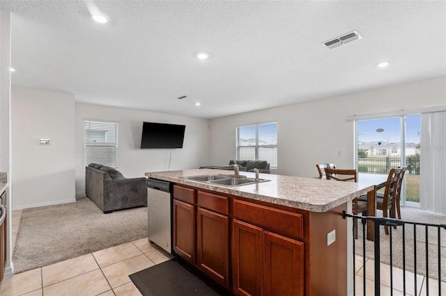 kitchen featuring light colored carpet, dishwasher, sink, and a center island with sink