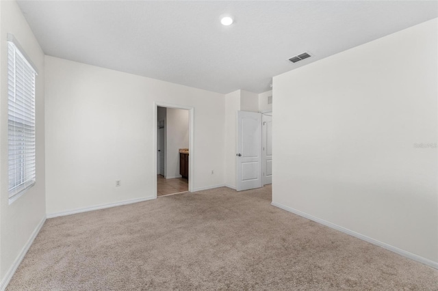 unfurnished room with light colored carpet