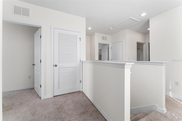 hallway featuring light colored carpet