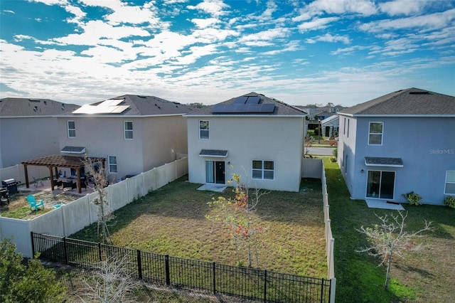 back of property with a gazebo, a lawn, and solar panels