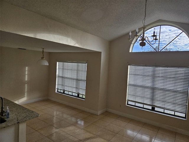 unfurnished dining area featuring a textured ceiling, vaulted ceiling, a healthy amount of sunlight, a chandelier, and light tile patterned flooring