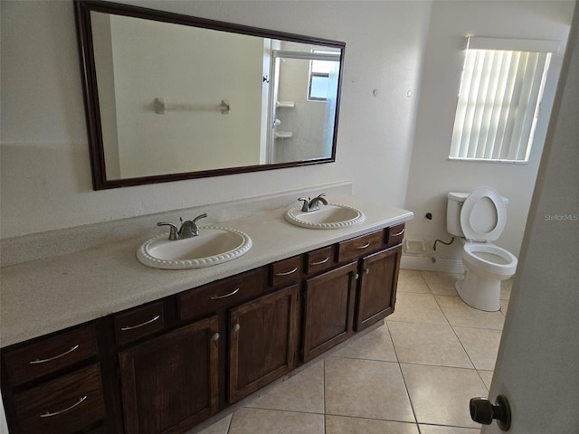 bathroom with toilet, vanity, and tile patterned flooring