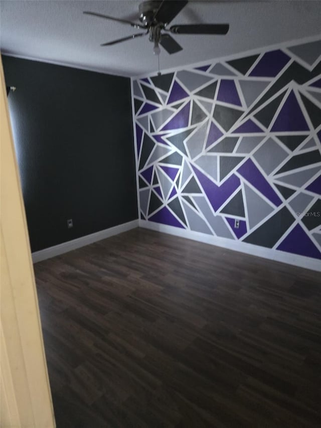 unfurnished room with a textured ceiling, dark wood-type flooring, and ceiling fan