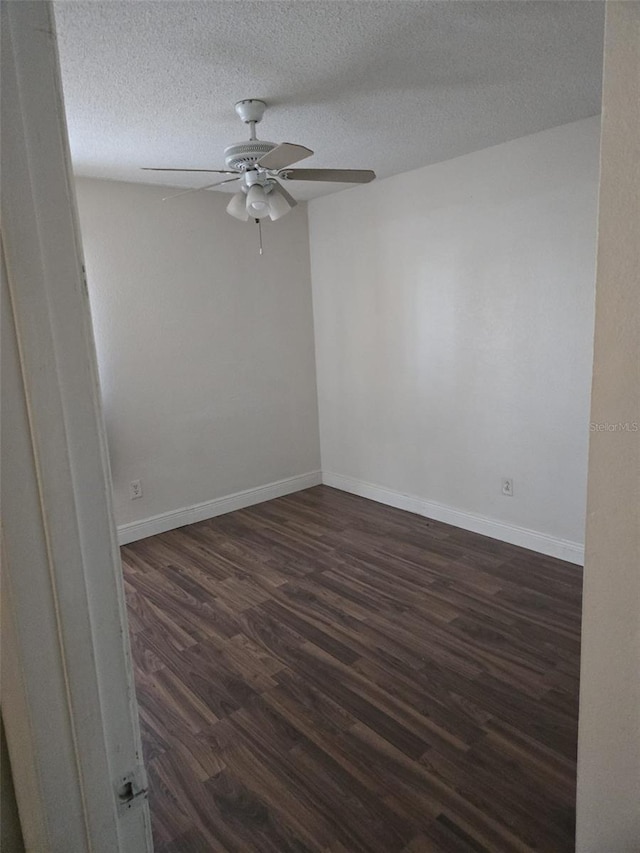 unfurnished room featuring ceiling fan, dark wood-type flooring, and a textured ceiling