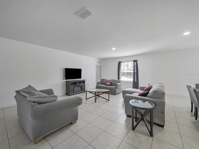 living room featuring a textured ceiling and light tile patterned floors