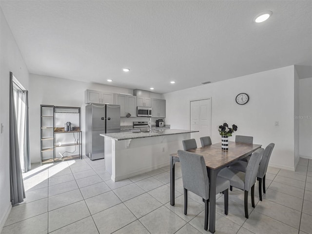 tiled dining room with sink and a textured ceiling