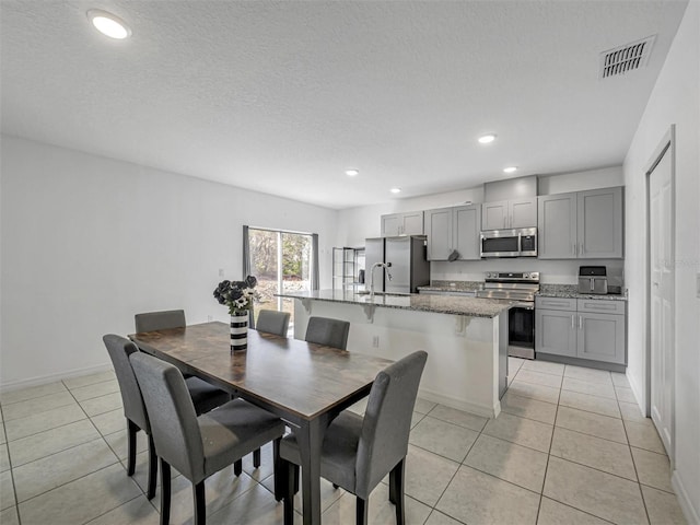 dining space featuring a textured ceiling and light tile patterned floors