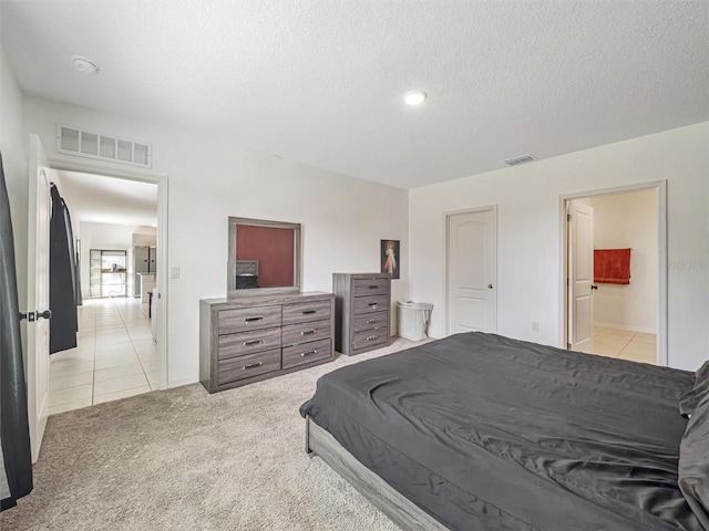 carpeted bedroom with a textured ceiling and ensuite bath