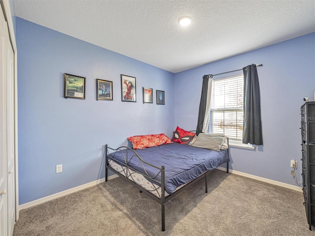 bedroom with a textured ceiling and carpet flooring