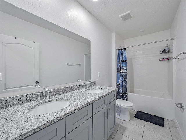 full bathroom featuring a textured ceiling, tile patterned flooring, vanity, shower / tub combo, and toilet