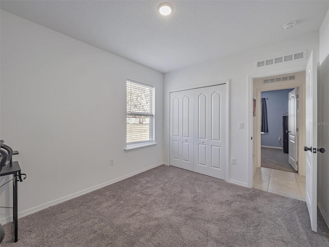 unfurnished bedroom with a closet and light carpet