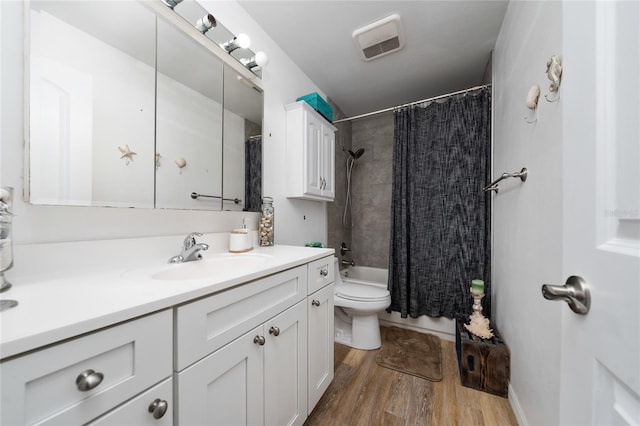 full bathroom featuring wood-type flooring, toilet, vanity, and shower / bathtub combination with curtain