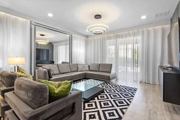 living room with an inviting chandelier and light wood-type flooring