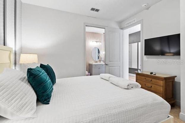 bedroom featuring carpet and ensuite bath