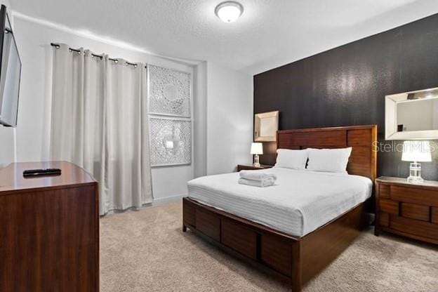 bedroom with light carpet and a textured ceiling