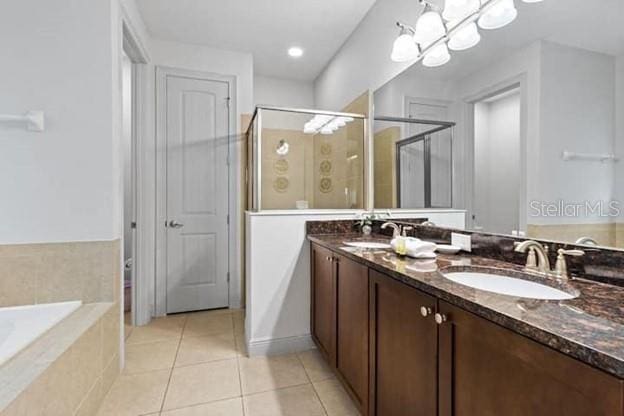 bathroom with tile patterned flooring, vanity, a chandelier, and separate shower and tub