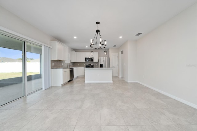 kitchen featuring decorative light fixtures, a center island, an inviting chandelier, white cabinetry, and stainless steel appliances