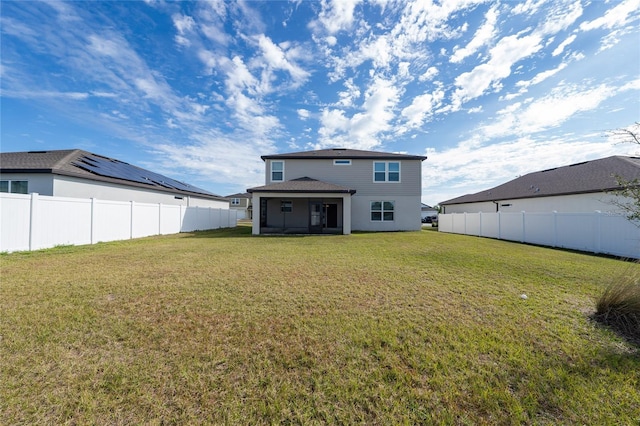 rear view of property featuring a yard